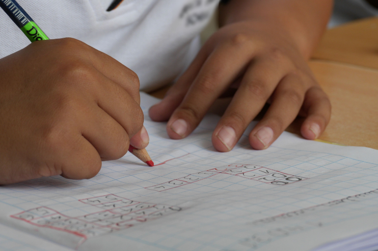 Boy writing numbers in a notebook