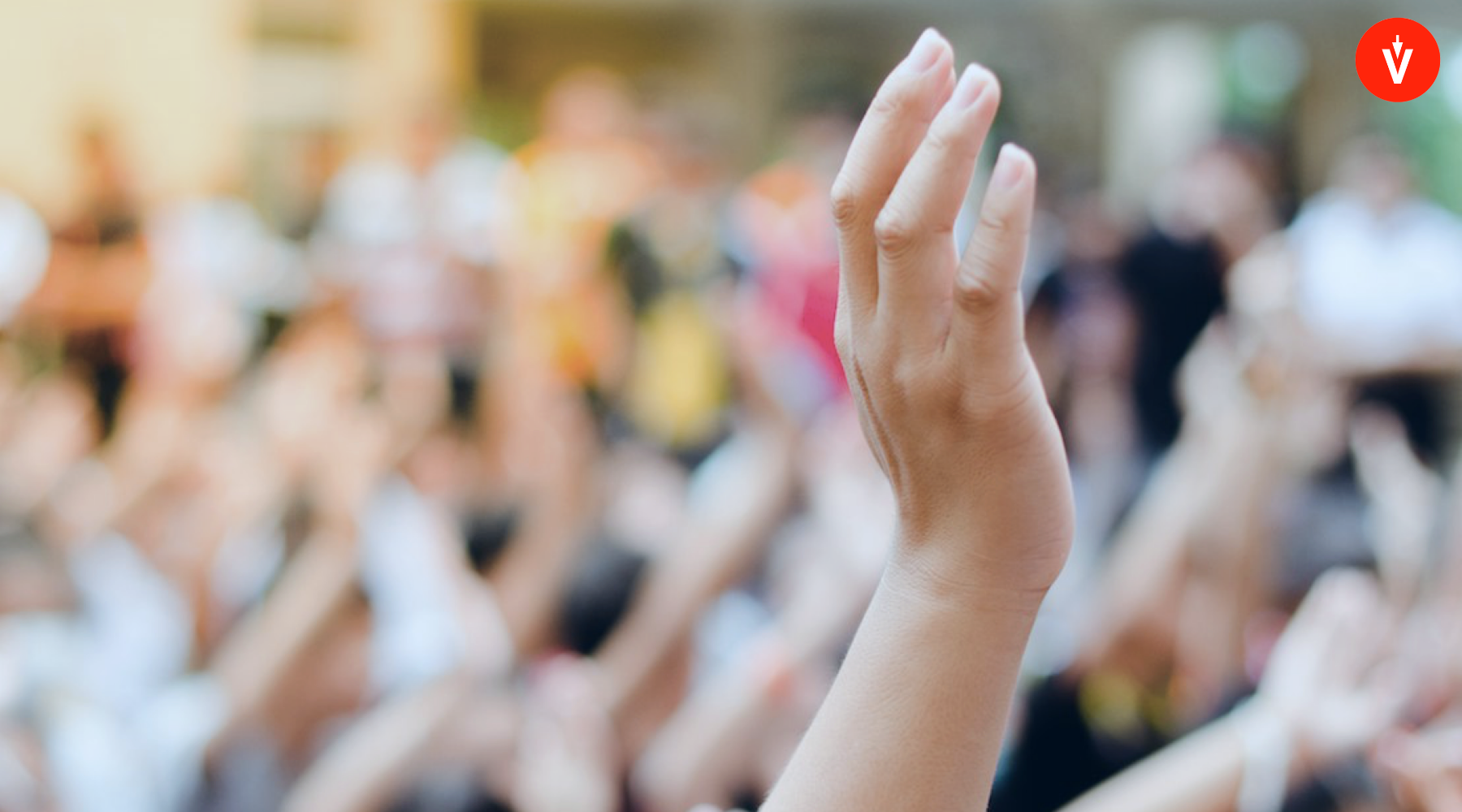 Una mano alzada entre una multitud, con logo de EVoting en la esquina