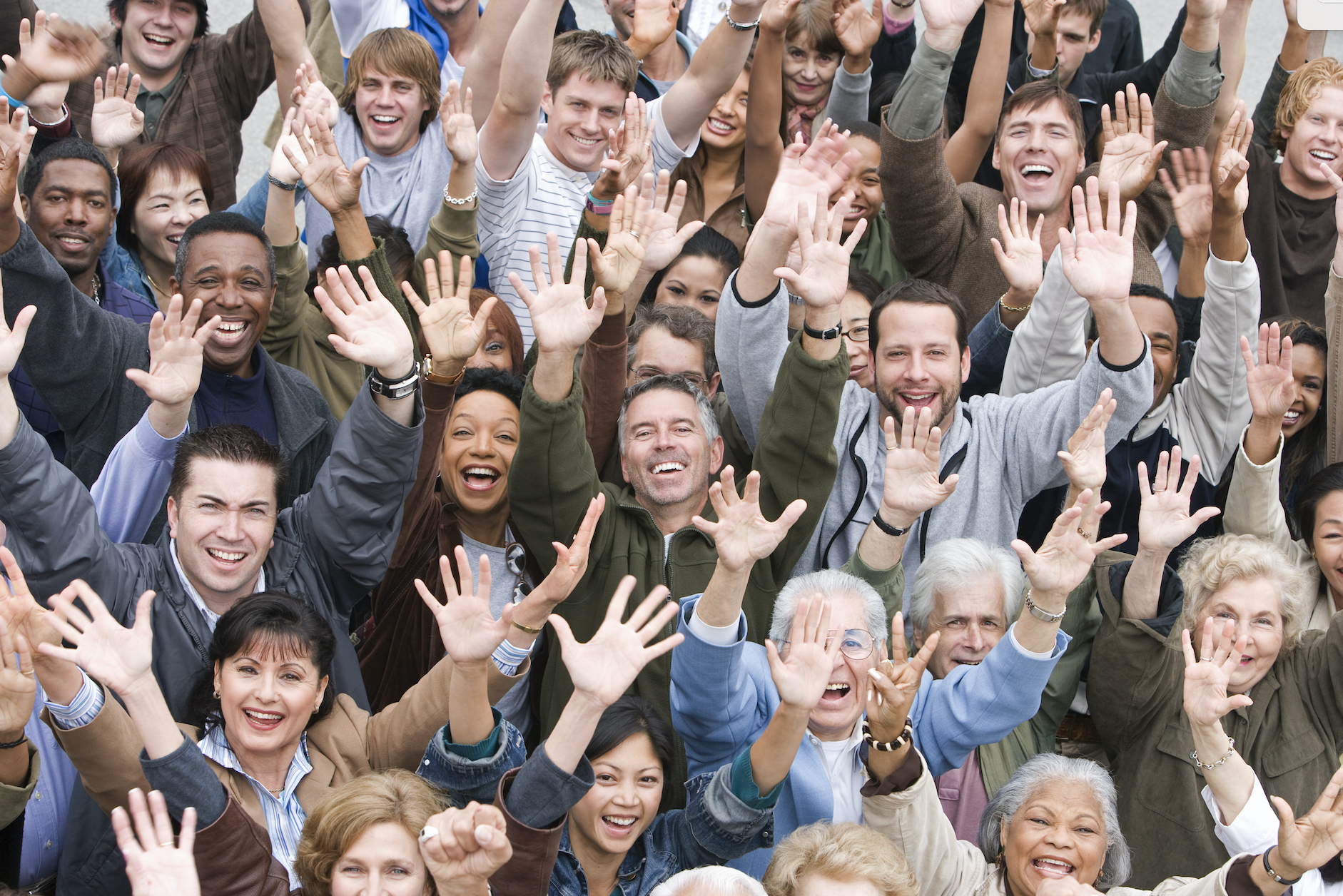 Grupo de personas sonriendo con sus manos en alto
